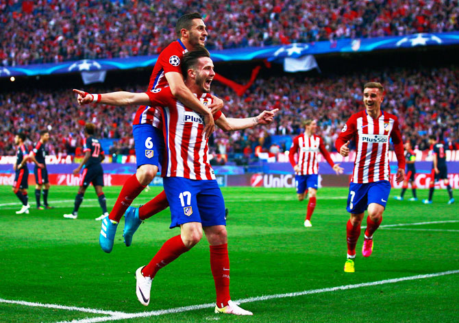 Atletico Madrid's Saul Niguez (17) celebrates with teammate Koke and others after scoring against Bayern Munich during the UEFA Champions League semi-final first leg match at Vincente Calderon Stadium in Madrid 