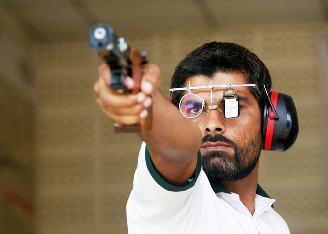 Ghulam Mustafa Bashir aims his pistol during a practice session at the Pakistan Navy Shooting Range in Karachi
