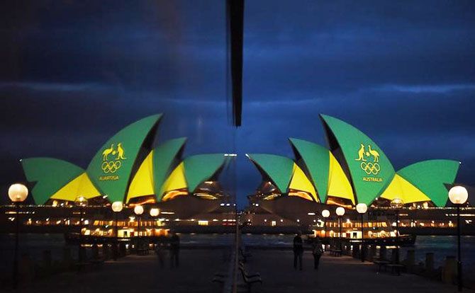 The Sydney Opera House is illuminated with the green and gold colours of the Australian Olympic team and reflected in a hotel window in Sydney, Australia, before the Olympics opening ceremony in Rio de Janeiro, Brazil, on Friday