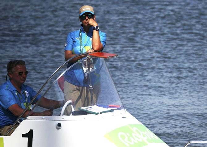 Race officials stand by in a boat shortly after competition in the Men's Single Sculls Repechages rowing was postponed due to high winds