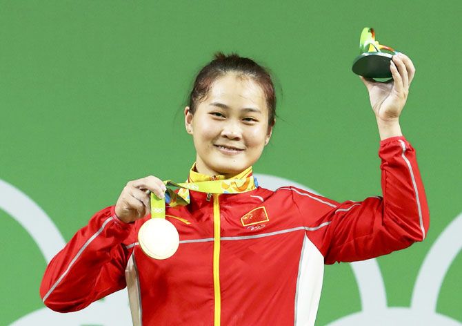 China's Deng Wei poses with her medal at the medal ceremony after winning her Women's 63kg wightlifting gold on Tuesday