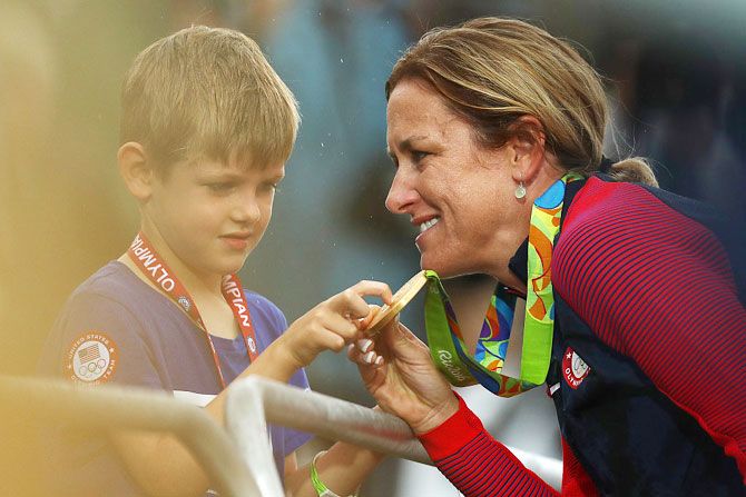 Gold medalist Kristin Armstrong of the United States shows her medal to her son Lucas William Savola after the medal ceremony for the Cycling Road Women's Individual Time Trial on Day 5 of the Rio 2016 Olympic Games at Pontal in Rio de Janeiro 