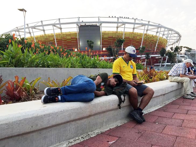 Spectators rest outside the Olympic Tennis Center at the Rio 2016 Olympic Games in Rio de Janeiro, on Tuesday