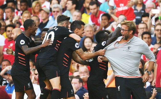 Liverpool's Sadio Mane and teammates celebrate his goal with manager Jurgen Klopp during their Premier League match against Arsenal at Emirates Stadium in London on Sunday