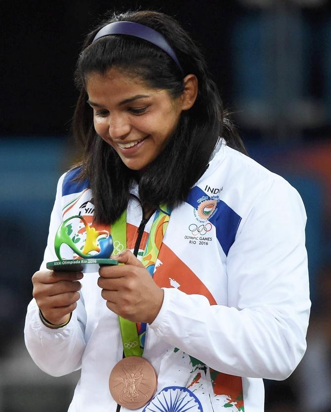 India's Sakshi Malik celebrates on the podium after receiving her bronze medal at the Rio Olympics