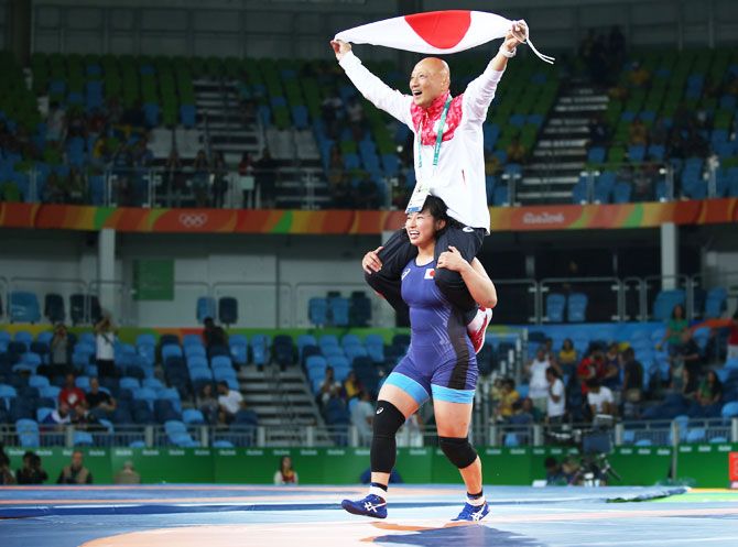 Sara Dosho of Japan celebrates with her coach after winning the gold medal in the Women's Freestyle 69 kg event on August 17
