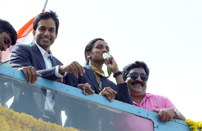 Rio Olympics silver medallist PV Sindhu and coach P Gopichand get a rousing reception atop an open-air bus in Hyderabad on Monday