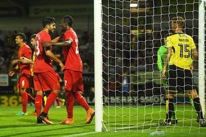 Liverpool's Emre Can (left) and Divock Origi celebrate the own goal scored by Burton Albion's Tom Naylor during their League Cup second round match at Pirelli Stadium in Burton upon Trent, England, on Tuesday