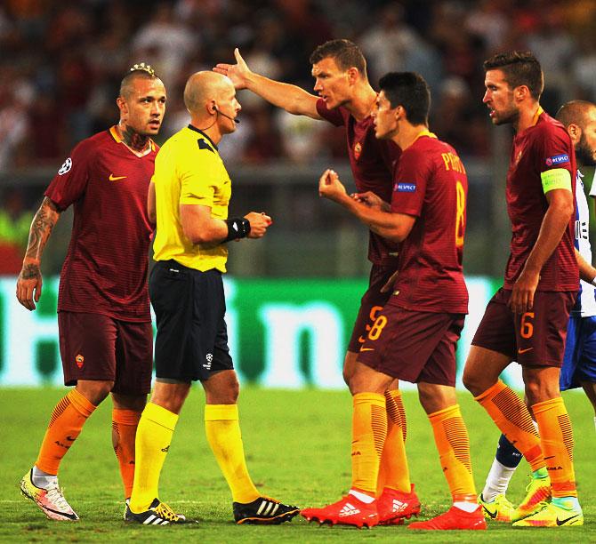 Edin Dzeko with his teammates of AS Roma protest to the the referee Szymon Marciniak during the UEFA Champions League qualifying playoff round second leg match against FC Porto at Stadio Olimpico in Rome on Tuesday