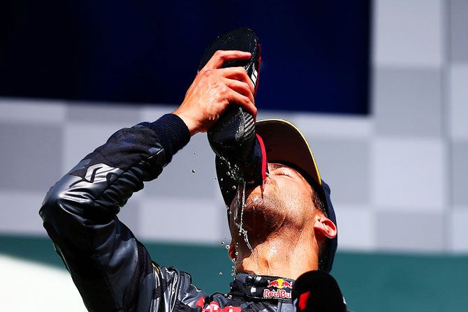 Red Bull Racing’s Australian driver Daniel Ricciardo drinks champagne from his boot as he celebrates on the podium during the Formula One Grand Prix of Belgium at Circuit de Spa-Francorchamps in Spa, Belgium, on Sunday