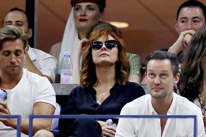 Veteran Hollywood actress Susan Sarandon (centre) watches the first round match between Novak Djokovic and Jerzy Janowicz