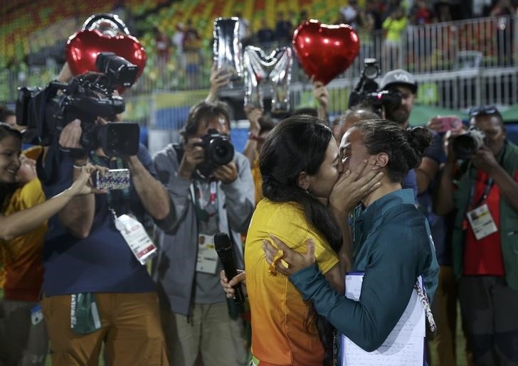 Rugby player Isadora Cerullo (BRA) of Brazil kisses Marjorie, a volunteer, after receiving her wedding proposal on the sidelines of the women's rugby medal ceremony