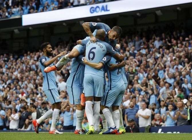 Manchester City's Raheem Sterling celebrates scoring their third goal with Aleksandar Kolarov and teammates
