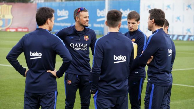 : FC Barcelona coach Luis Enrique speaks to his players at a training session