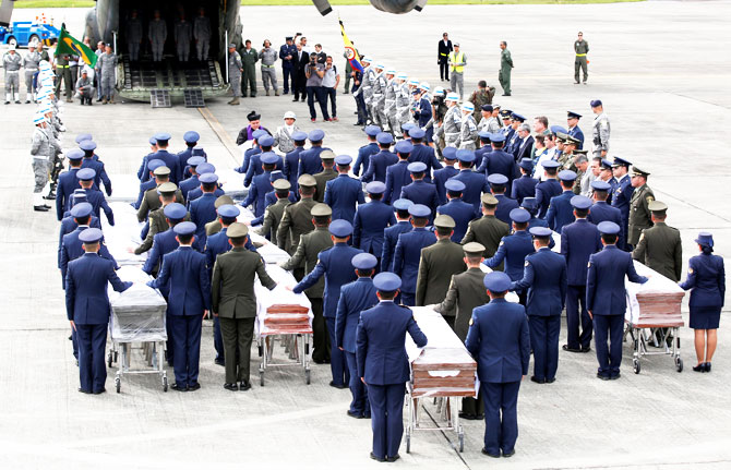 Military personnel unload a coffin with the remains of Brazilian victims who died in an accident of the plane that crashed into the Colombian jungle with Brazilian soccer team Chapecoense, at the airport from where the bodies will be flown home to Brazil, in Medellin, Colombia on Friday
