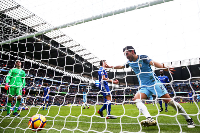 Manchester City's Ilkay Gundogan celebrates his team's first goal as Chelsea's Gary Cahill scores an own goal