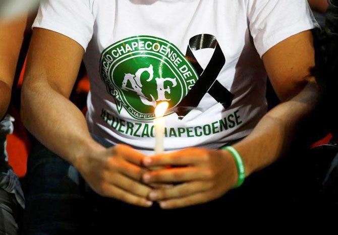 A fan of Atletico Nacional soccer club holds a candle and wears a shirt in support while paying tribute to the players of Brazilian club Chapecoense killed in the airplane crash, in Medellin, Colombia, on November 30, 2016