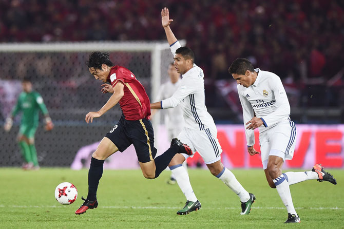 Kashima Antlers' Mu Kanazaki runs past Real Madrid's Raphael Varane as they vie for possession