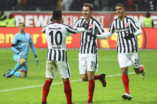 Eintracht Frankfurt's Branimir Hrgota (centre) celebrates his goal against FSV Mainz 05 with Marco Fabian (left) and Ayman Barkok during their match against Mainz 05 at Commerzbank Arena, in Frankfurt on Tuesday