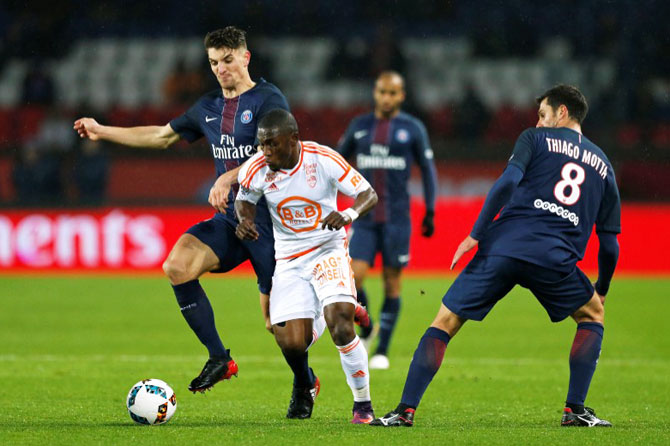 Paris St Germain's Thomas Meunier (left) is challenged by FC Lorient's Majeed Waris (centre)