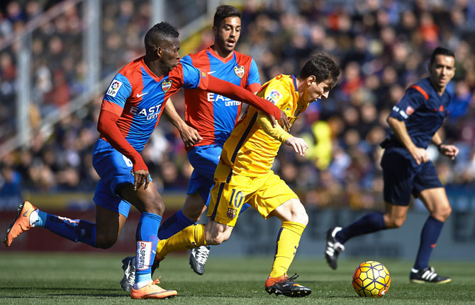 FC Barcelona's Lionel Messi is challenged by Levante's Lerma