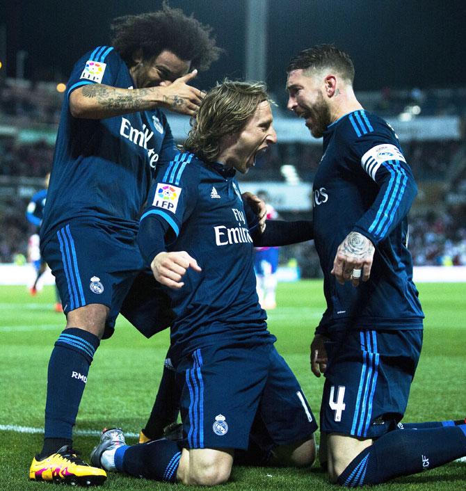 Real Madrid's Luka Modric celebrates scoring their second goal with teammates Sergio Ramos (right) and Marcelo (left) during the La Liga match against Granada CF at Estadio Nuevo Los Carmenes in Granada on Sunday