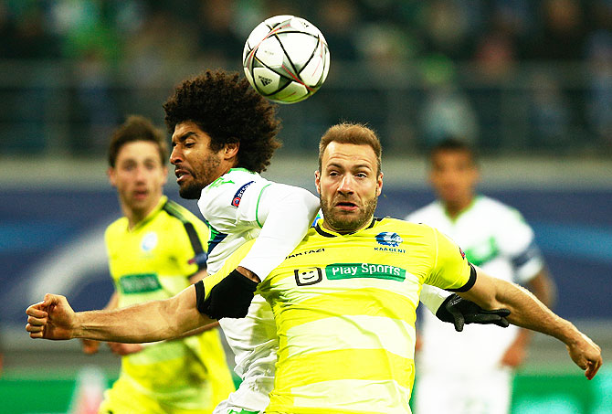 Wolfsburg's Dante and Gent's Laurent Depoitre compete for the ball