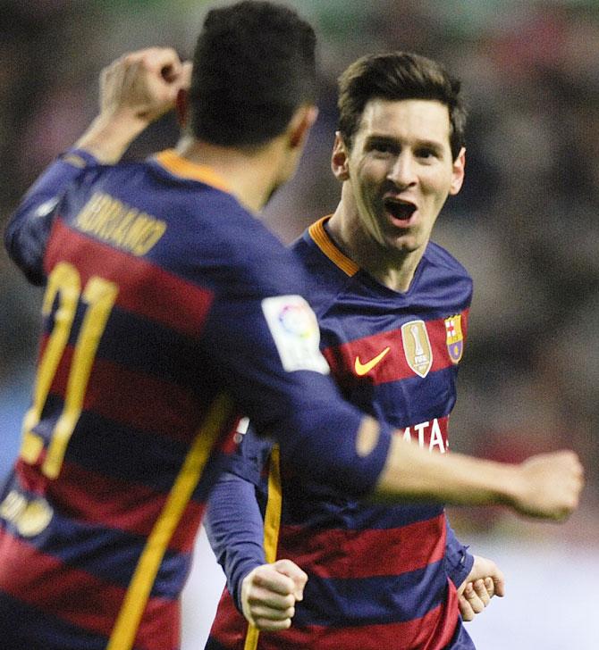 Barcelona's Lionel Messi celebrates with teammate Adriano after scoring a goal against Sporting Gijon at the El Molinon stadium, in Gijon on Wednesday