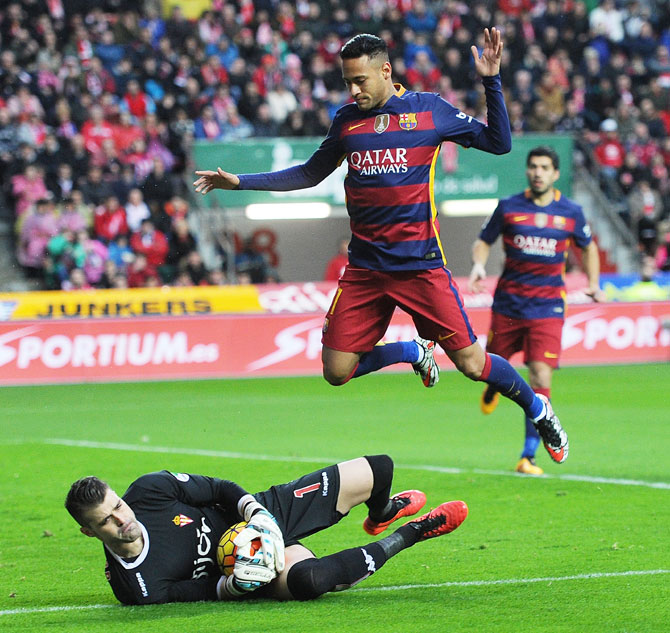 FC Barcelona's Neymar jumps over Sporting Gijon 'keeper Ivan Cuellar