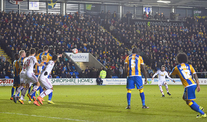 Manchester United's Juan Mata (2nd from right) scores their second goal from a free-kick during the Emirates FA Cup fifth round match against Shrewsbury Town at Greenhous Meadow in Shrewsbury, England on Monday