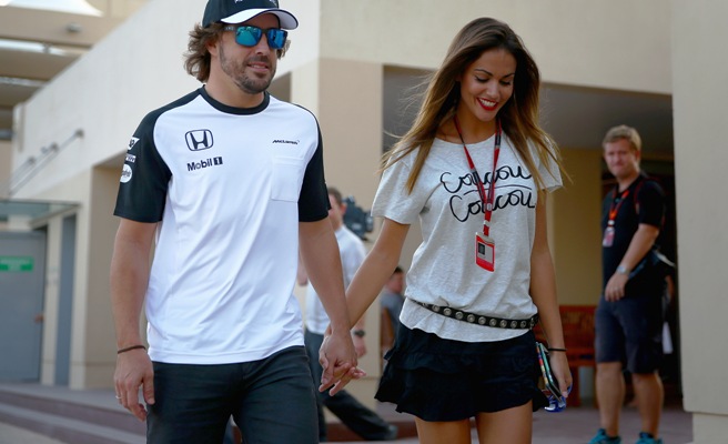 Fernando Alonso of Spain walks in the paddock with his girlfriend Lara Alvarez 