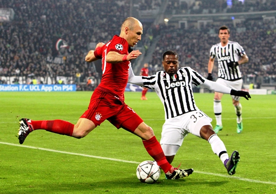 Arjen Robben of FC Bayern Muenchen is challenged by Patrice Evra of Juventus FC 