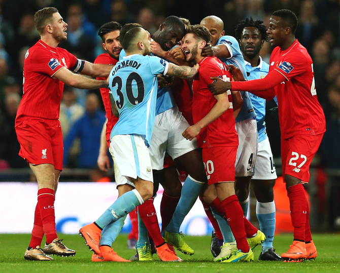 Manchester City's Yaya Toure and Liverpool's Adam Lallana clash as players intervene