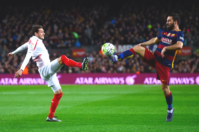 FC Barcelona's Arda Turan (right) and Sevilla FC's Sebastian Cristoforo vie for the ball