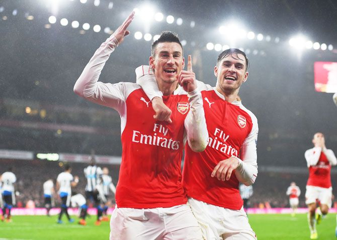 Arsenal's Laurent Koscielny (left) celebrates with his teammate Aaron Ramsey after scoring his team's first goal against Newcastle United during their Barclays English Premier League match at Emirates Stadium in London on Saturday
