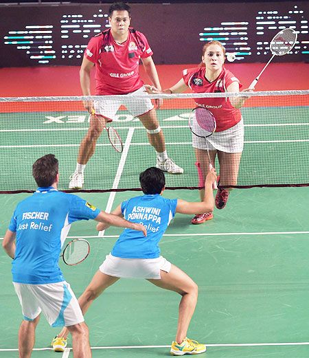Hyderabad Hunters' Jwala Gutta, and Markis Kido (Red) pkay a return against Bangaluru Topguns' Ashwini Ponnappa and JF Nielse (Blue) in their mixed doubles match at the Premier Badminton League in Mumbai on Sunday