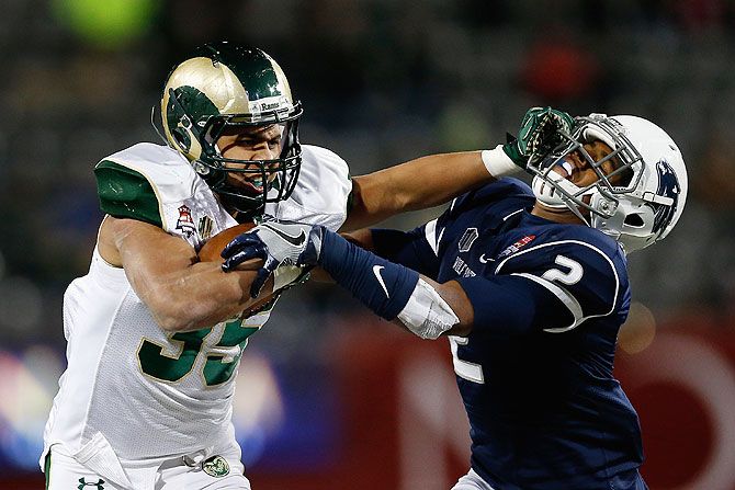 Running back Izzy Matthews #35 of the Colorado State Rams stiff arms defensive back Asauni Rufus #2 of the Nevada Wolf Pack as he rushes the football during the Nova Home Loans Arizona Bowl American Football match at Arizona Stadium in Tucson, Arizona on Tuesday, on December 29 2015