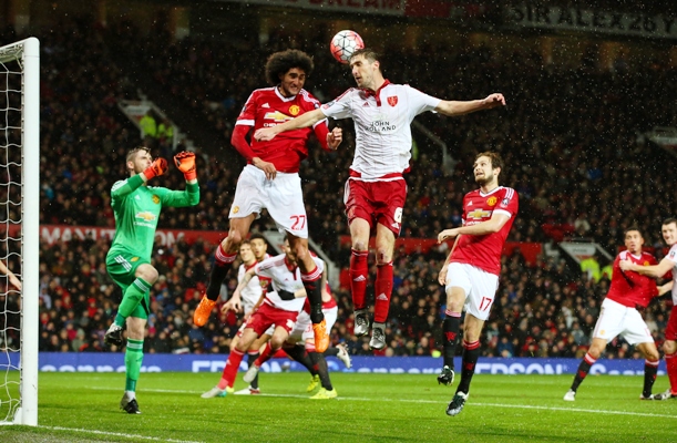 Chris Basham of Sheffield United wins a header from Marouane Fellaini of Manchester United 