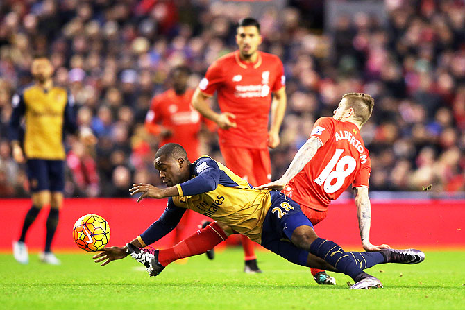 Arsenal's Joel Campbell and Liverpool's Alberto Moreno vie for possession