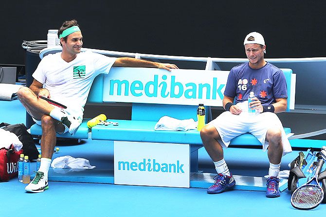 Switzerland's Roger Federer (left) talks with Australia's Lleyton Hewitt during a practice session at Melbourne Park on Friday