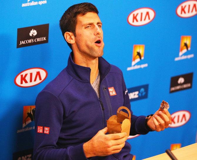 Novak Djokovic reacts when eating one of his chocalates that he gave away to media on Sunday