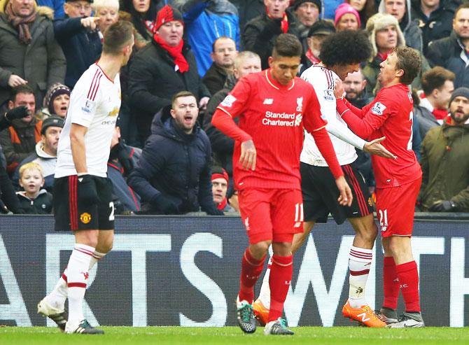 Manchester United's Marouane Fellaini clashes with Liverpool's Lucas Leiva