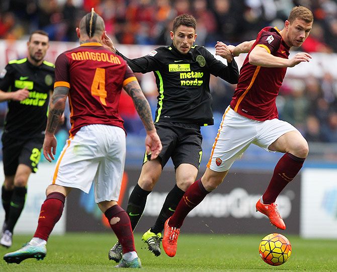 AS Roma's Edin Dzeko (right) competes for the ball with Hellas Verona's Leandro Greco (centre) during their Serie A match at Stadio Olimpico in Rome on Sunday
