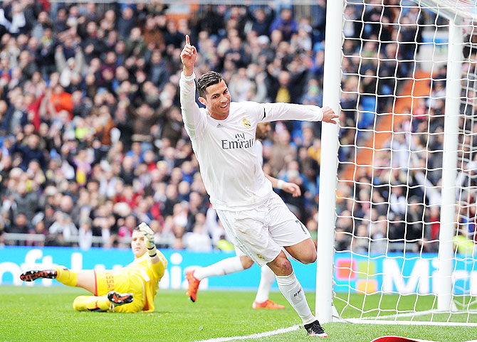 Real Madrid's Cristiano Ronaldo celebrates after scoring his team's 4th goal against Sporting Gijon at Estadio Santiago Bernabeu