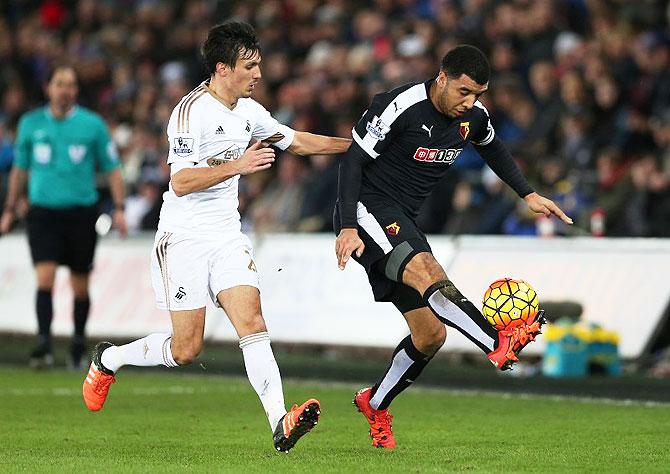 Swansea's Jack Cork and Watford's Troy Deeney vie for possession