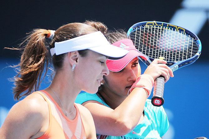 Switzerland's Martina Hingis and India's Sania Mirza discuss between points in their second round women's doubles match against Ukraine's Lyudmyla Kichenok and Nadiia Kichenok at the 2016 Australian Open at Melbourne Park on Saturday