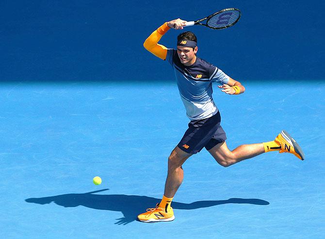 Milos Raonic plays a return against Stan Wawrinka