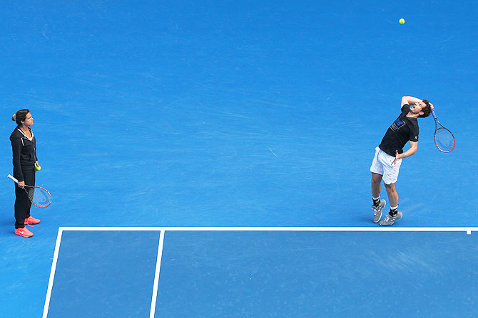 Great Britain's Andy Murray serves as coach Amelie Mauresmo looks on during practice on Saturday