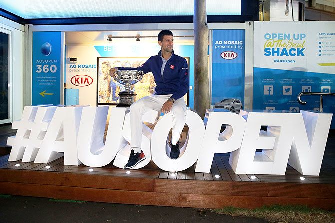 Serbia's Novak Djokovic poses with the Norman Brookes Challenge Cup after winning the Australian Open men's final after defeating Great Britain's Andy Murray on Sunday