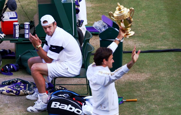 Andy Roddick looks despondent as Roger Federer celebrates
